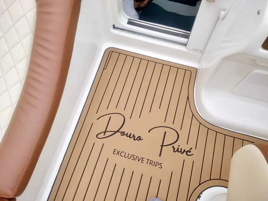 Piso náutico com a marca Douro Privé gravada, junto a estofos em pele clara